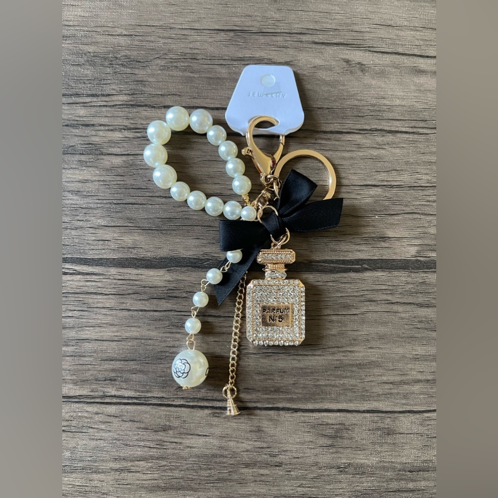 NWT: A parfum bottle with black ribbon and purse charm or keychain.